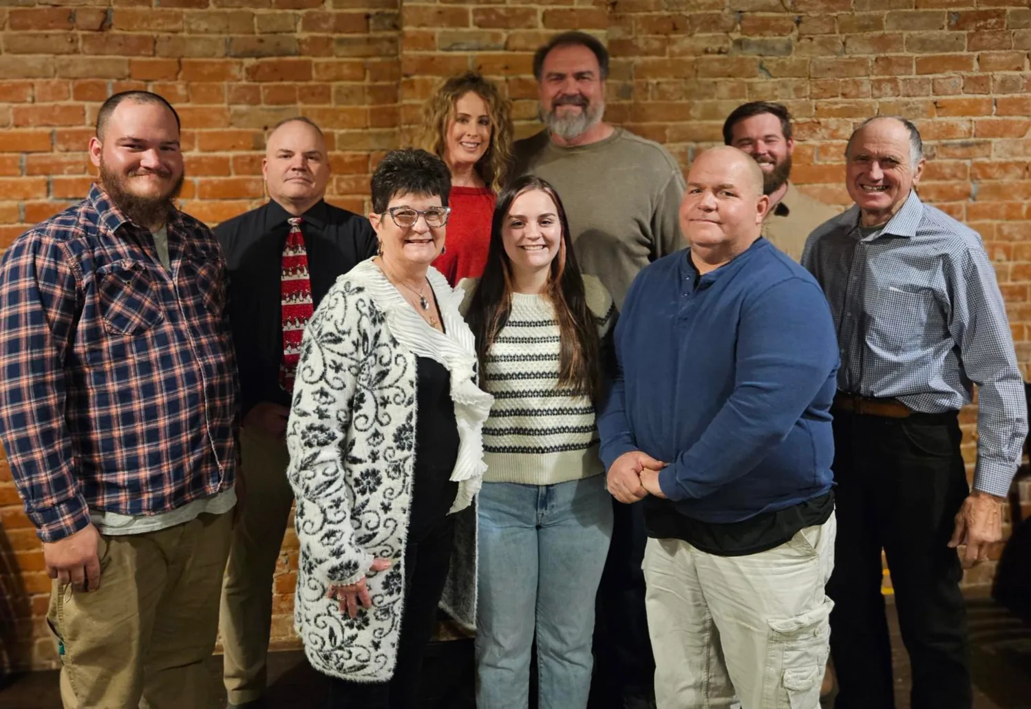 The Hoskins Exteriors team, standing together in front of a brick wall