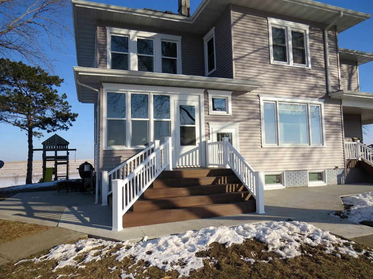 Two-story home with pale siding, white trim and white stair railings