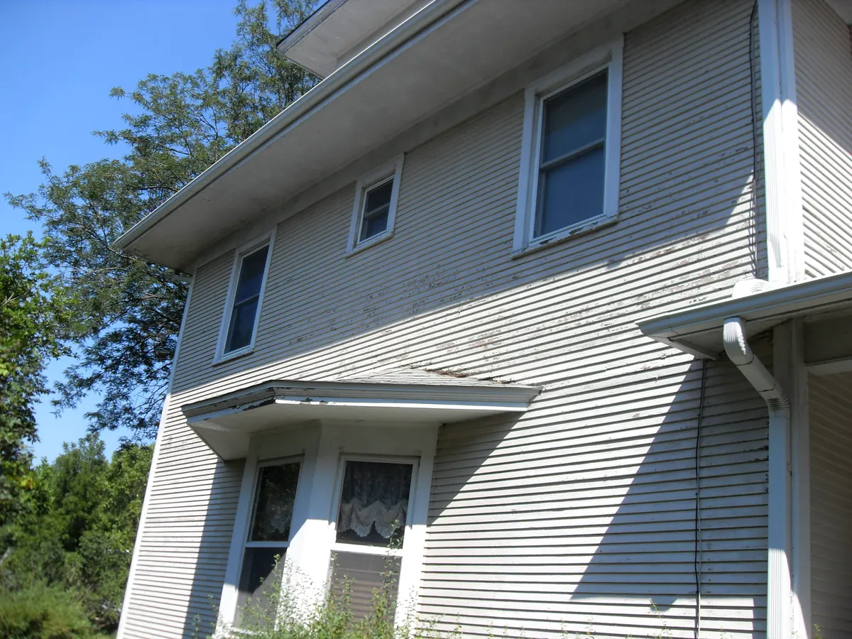 Two-story home with pale lap siding and white windows
